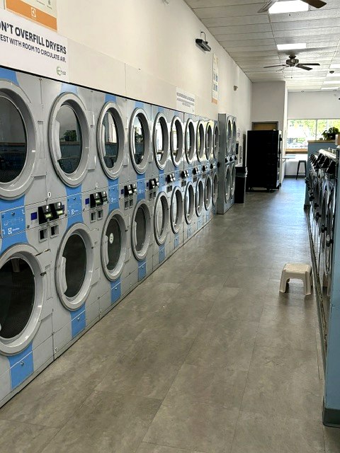 A long row of clean, high-capacity stacked machines at Scrubs Laundry in Chelsea